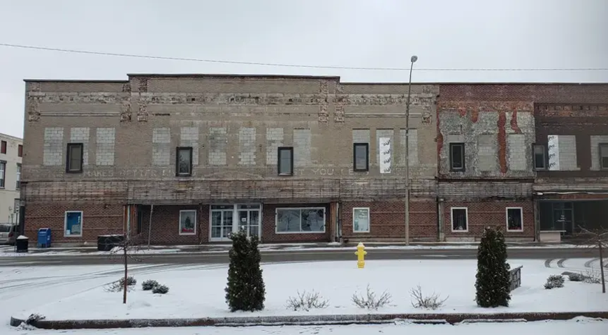 Deteriorated brick structure in wintertime with snow in the foreground.  